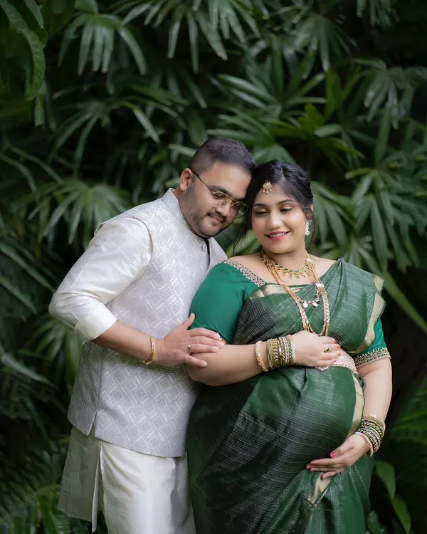 An intimate portrait from an outdoor maternity session. The lush green background provides a natural and peaceful setting for capturing the connection between the parents-to-be.