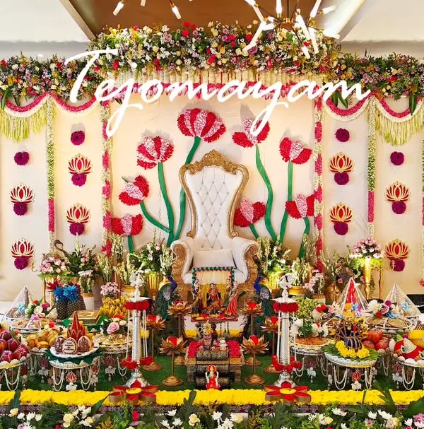 This aesthetic plate decoration for a baby shower features a grand floral backdrop with a throne, creating a royal setting for the mother-to-be. The entire stage is filled with meticulously arranged traditional offerings.