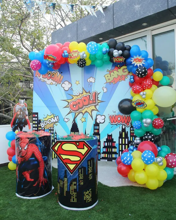 Kapow! A super backdrop for a superhero-themed party, featuring comic book graphics and character stands for Superman and Spider-Man.