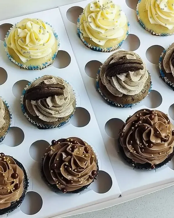 This is my classic assortment box, perfect for any occasion or when you can't decide on just one flavor. It features rows of my signature Chocolate, Vanilla, and Oreo cupcakes, each with its own distinct and delicious topping.