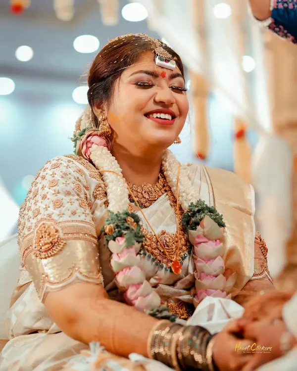 The pure joy of a wedding ceremony. This candid shot captures the bride's beautiful, uninhibited laughter during a traditional ritual.