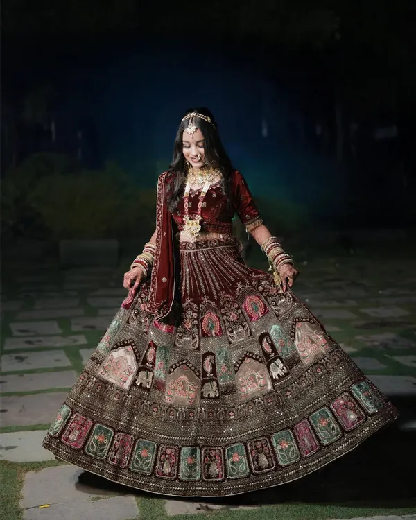 A beautiful full-length portrait of the bride twirling in her intricately designed lehenga. The outdoor setting and her joyful expression perfectly capture the magic of her wedding day.