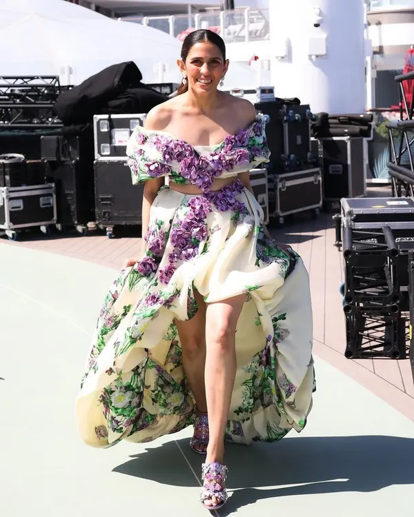 This Yara Shoemaker floral gown is pure romance. The off-shoulder design, 3D floral details, and high-low skirt make it a perfect statement piece for a summer gala or a destination event.
