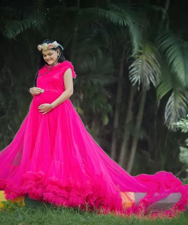 Make a bold statement with this vibrant fuchsia gown. Its long, ruffled train adds drama and movement, perfect for creating stunning portraits in any outdoor setting.