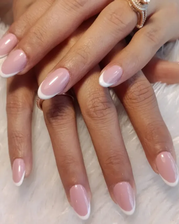 The epitome of elegance: a perfect, classic French manicure on medium-length oval nails. This timeless look is always in style.