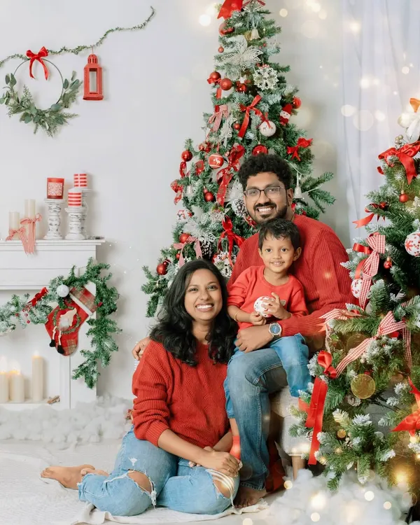 A picture perfect holiday moment. This family's coordinated red sweaters and joyful smiles make for a classic Christmas card photo, full of warmth and festive cheer.