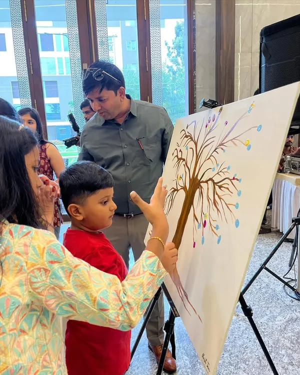 A father and son adding their thumbprints to a family tree canvas. It’s a beautiful way for guests of all ages to leave their mark.