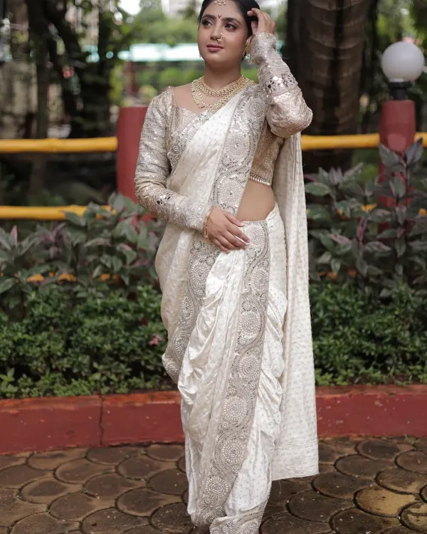This white pre-stitched Nauvari saree with silver embroidery is the definition of grace. The full-sleeve blouse adds a modern touch to the traditional drape.