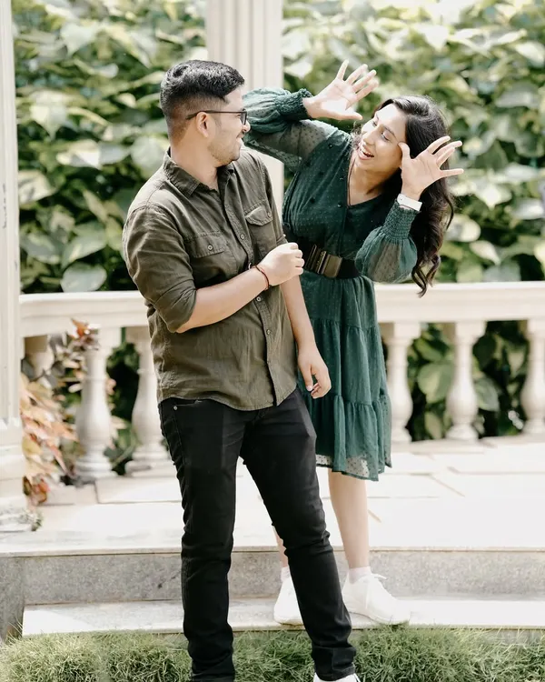 A hilarious, candid moment of a couple being goofy and playful in a garden gazebo, showing their fun-loving side.