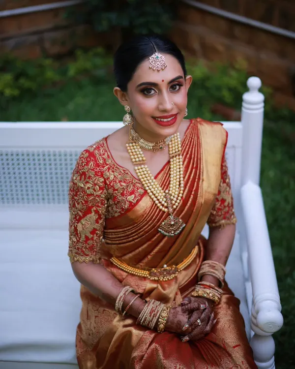 This is my signature South Indian bridal look. I focused on creating luminous, skin-like makeup with a classic red lip that complements the rich Kanjeevaram saree and traditional gold jewelry. The goal is a timeless elegance that looks fresh and radiant throughout the wedding ceremony.