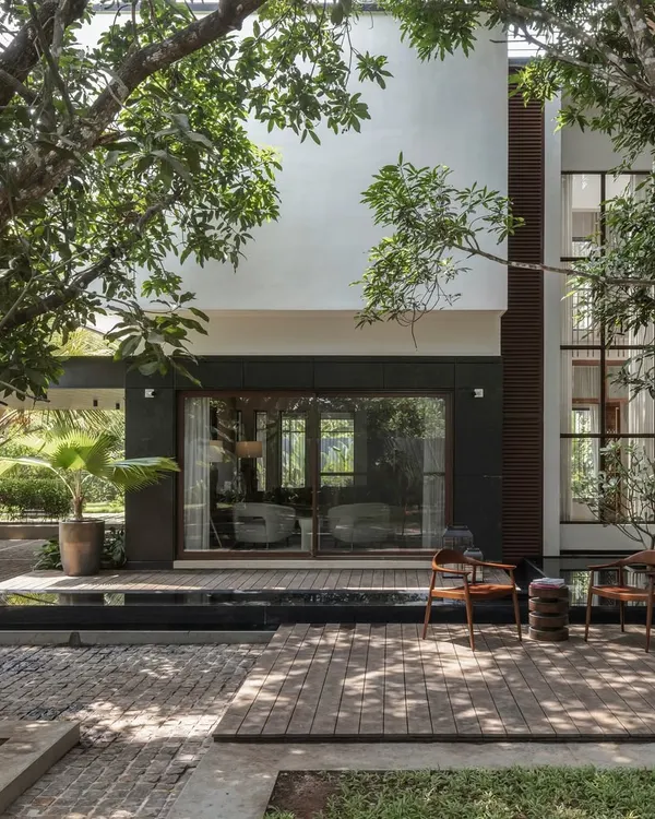 This is the Mango Tree Yard residence in Thrissur, a home designed around two magnificent, mature mango trees. We created a pavilion-style layout that embraces the natural landscape, with a serene backyard deck and waterbody for quiet reflection. The design merges contemporary architecture with traditional Kerala spatial planning, resulting in a home that is both modern and deeply rooted.