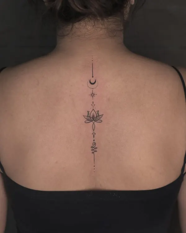 An elegant and beautiful spine tattoo. This fine-line design uses minimalist symbols like the moon, lotus, and unalome to create a piece that flows perfectly with the body's natural curvature.