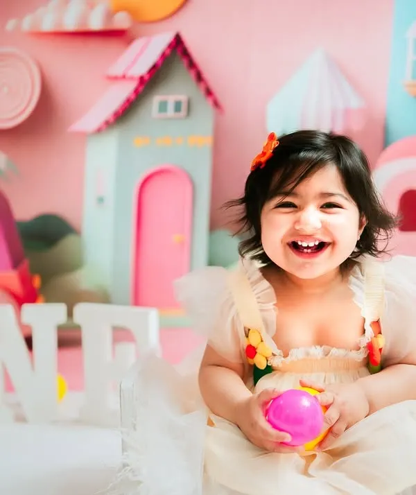 A smile that lights up the whole city. This little girl's first birthday was celebrated in style with a custom pink city theme, creating a playful and imaginative world just for her.