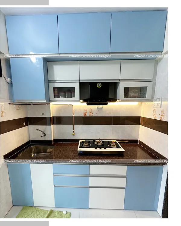 A compact and efficient modular kitchen designed for a 1BHK apartment in Dronagiri. The blue and white acrylic finish gives it a fresh and modern look, while the layout maximizes storage and workspace.