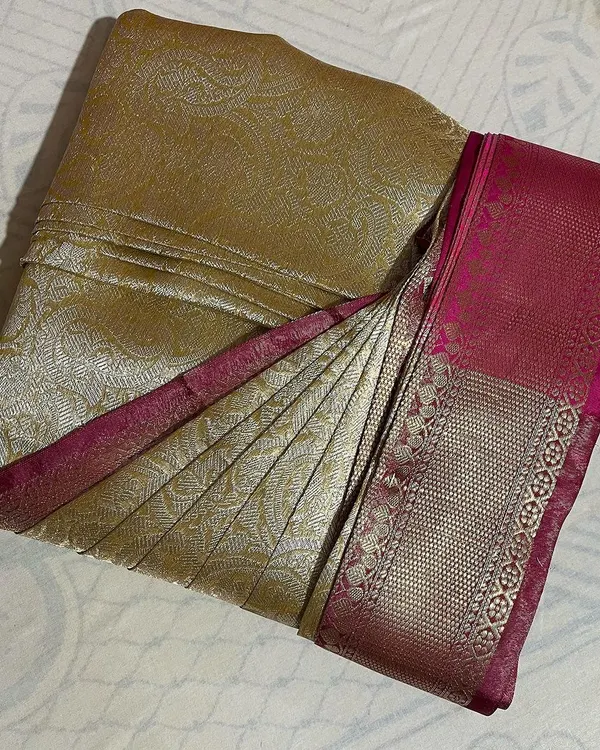 A stunning gold and pink Kanchipuram silk saree, perfectly box-folded to preserve its shape and prevent damage.