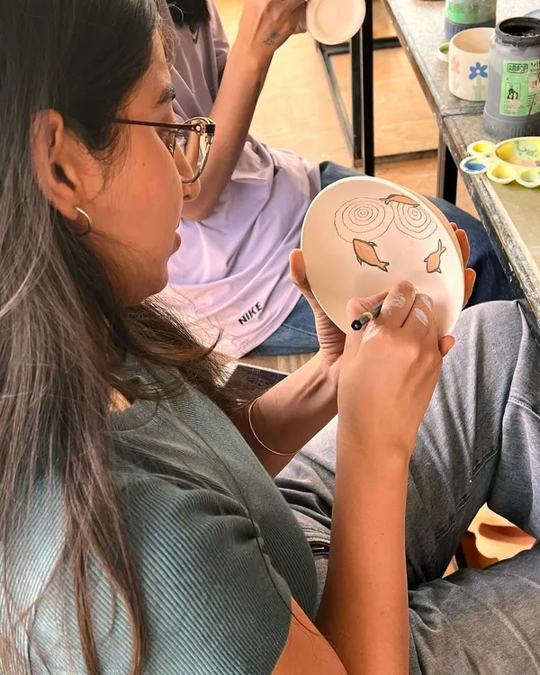 It's a very proud moment for me when my students enjoy the process and create beautiful pieces with so much love. This student is carefully painting a fish design on her handmade plate.
