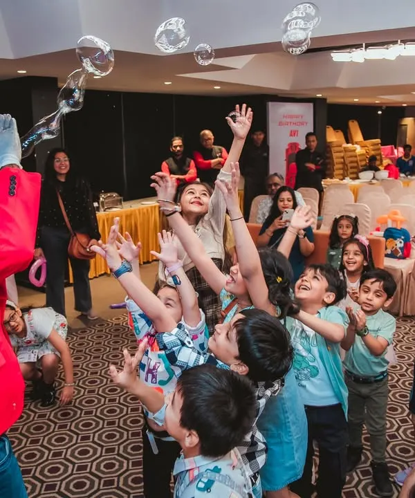 A bubble show entertainer mesmerizes a crowd of excited children as they reach for the floating bubbles. This show brings a sense of wonder and delight to any party.
