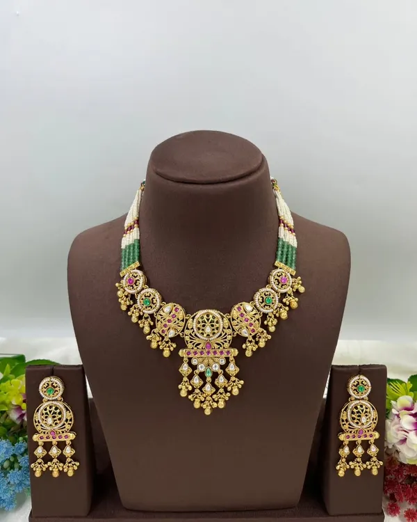 An antique-style necklace set with intricate detailing and multi-color stones, shown from different angles.