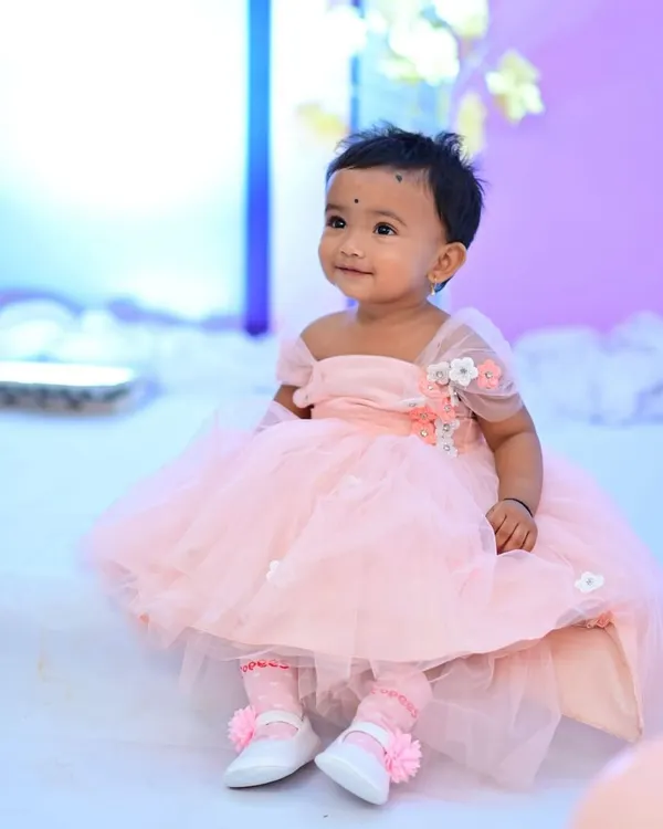 An adorable little client in her custom-designed pink party dress. This dress features a tulle skirt and 3D floral embellishments on the shoulder.