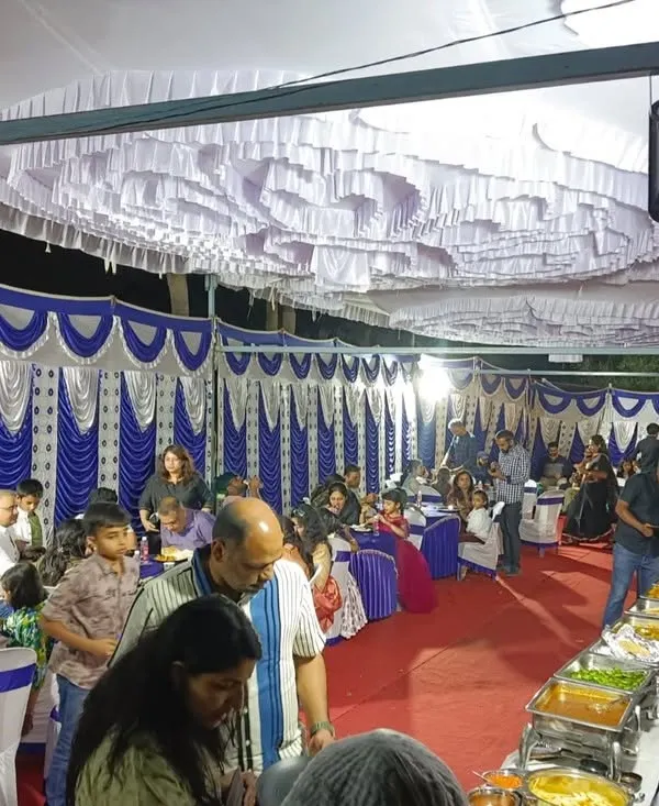 A large-scale housewarming party with a full tent setup. Our team seamlessly manages the buffet line, serving a large number of guests in an outdoor setting.