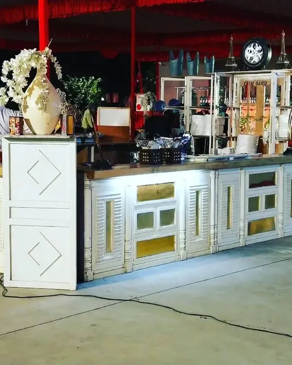 This is one of our custom counter designs, featuring a white and gold theme perfect for an elegant outdoor or sangeet event. The intricate details and built-in shelving allow for a beautiful and functional display.
