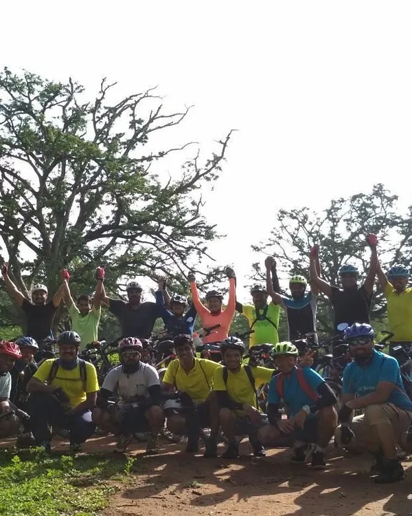 Victory poses are a must after a fun trail ride. The whole group celebrating together in the middle of the Nallur Tamarind Grove.