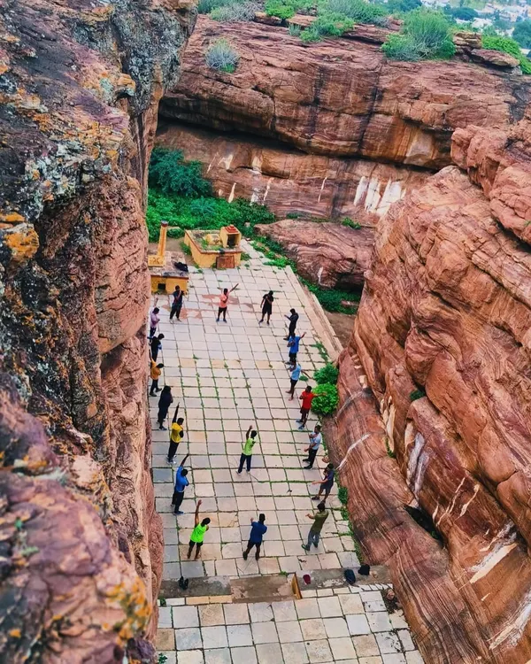 A unique perspective from above, showing our group warming up in a historic courtyard nestled between the magnificent cliffs of Badami before a day of climbing.
