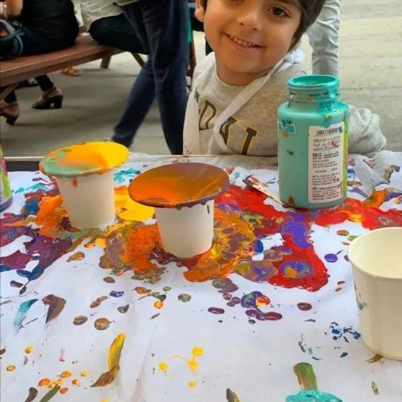 That happy smile says it all. My fluid art stations are designed to be a fun, sensory experience for children, letting them explore colors and textures in a playful way.