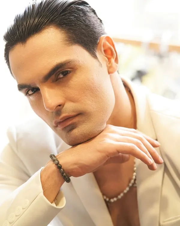 For this men's editorial, the goal was a sharp, high-fashion look. I used a clean base to even out the skin tone and styled the hair with a sleek, wet finish to complement the modern, edgy styling.