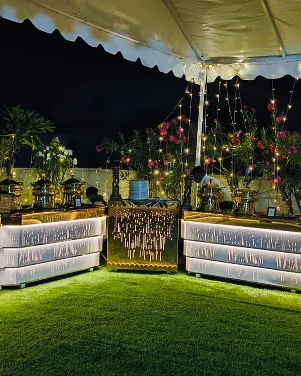 My premium banquet hall in Sahakarnagar, set up for an evening event. The rooftop garden space with illuminated counters creates a beautiful ambiance for any occasion.