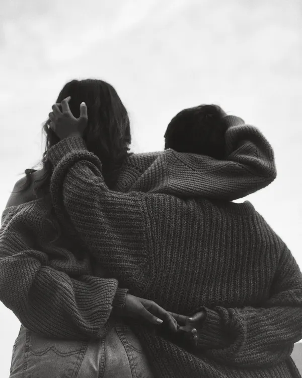 An at-home session is perfect for capturing genuine intimacy. This black and white close-up focuses on the texture and feeling of a simple embrace, stripping away everything but the emotion.