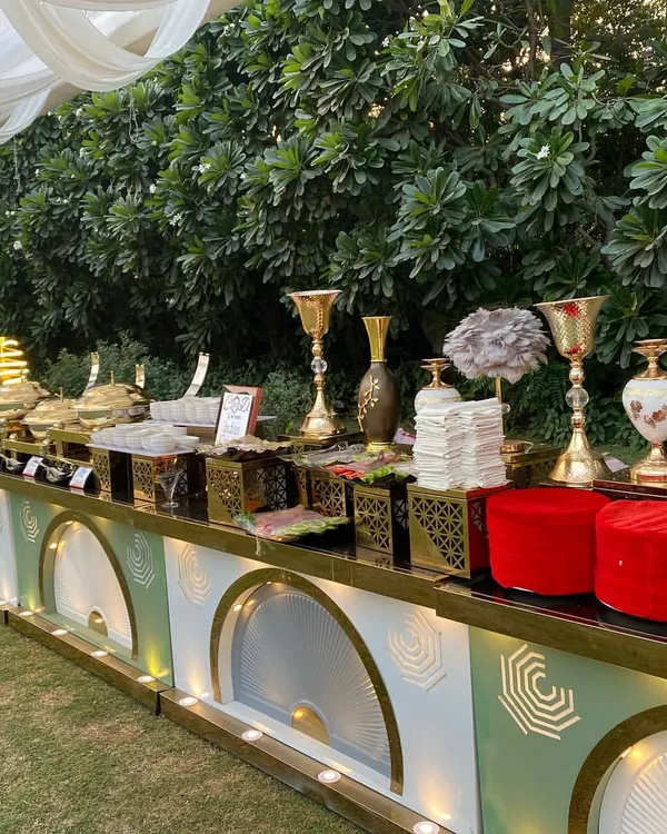 This is the standard we bring to every outdoor wedding celebration. A sprawling buffet line featuring elegant, modern counters with gold accents, premium chafing dishes, and tasteful decor, all set up to create a stunning visual feast for your guests.