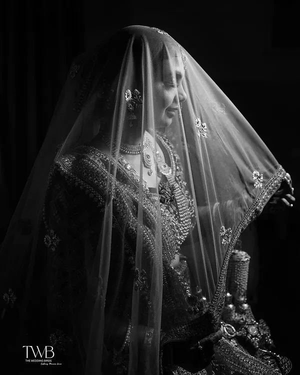 A bride veiled in mystery and elegance. This black and white portrait uses the sheer dupatta and soft light to create a dreamy, timeless, and artistic image.