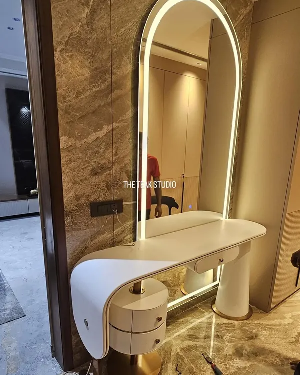 I love creating statement pieces like this custom dresser. It features a minimalist curved design, a built-in arched mirror with ambient LED lighting, and unique cylindrical drawers with brass details for a touch of glamour.