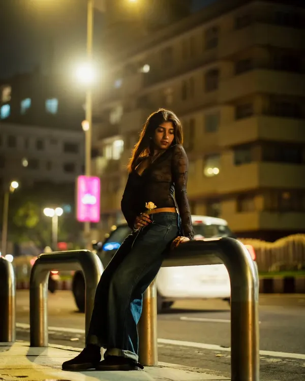 A full-body portrait from a night shoot in Mumbai. I used a street barrier as a prop to create a relaxed, editorial pose against the backdrop of city lights.