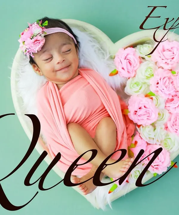 A perfect, happy smile on a sleeping baby. Swaddled in pink and surrounded by flowers in a heart-shaped bowl, this is the definition of a sweet and timeless newborn portrait.