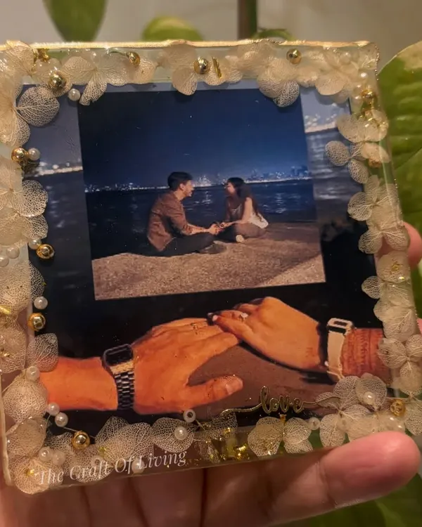 One frame, endless emotions. This custom resin photo frame turns your favorite picture into a timeless keepsake, bordered with delicate fabric flowers and pearls.