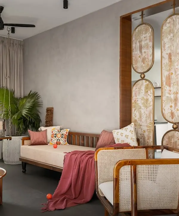 This living room from the 'Ittige' project is a perfect example of our integrated approach. The space flows seamlessly, furnished with a mix of contemporary sofas, a traditional swing, and artful partitions that define areas without closing them off.