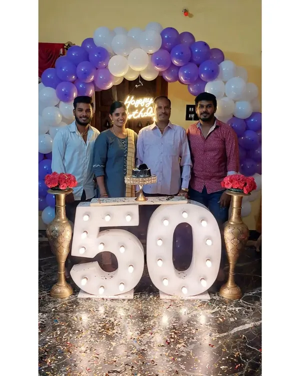 A family celebrating a 50th birthday with our marquee number setup. The large, lit-up "50" provides the perfect centerpiece, framed by a purple and white balloon arch for a festive and memorable family photo.