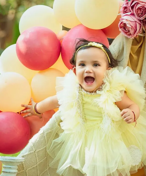 The pure joy of an outdoor celebration. This little girl's excitement is infectious in this beautiful park setting with a teepee and balloons.