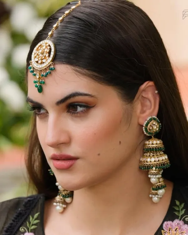 A close-up of our beautiful green beaded jhumkas and matching maang tikka. These accessories are perfect for adding a pop of color and traditional flair to any outfit.