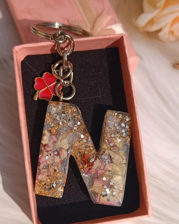 This 'N' alphabet keychain is filled with a customer's special flower petals, silver glitter, and gold flakes. I added a lucky four-leaf clover charm to finish the piece.