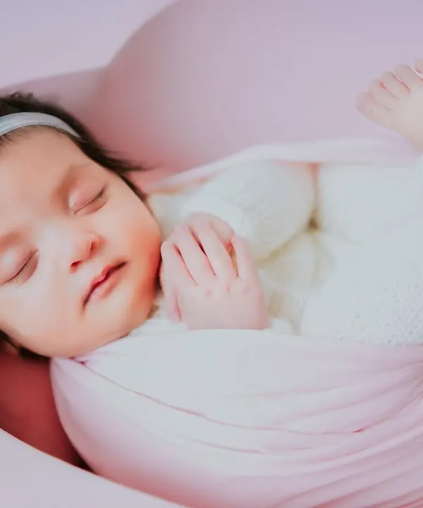 So tiny, so perfect, so loved. This newborn girl is sleeping peacefully in a heart-shaped bowl, a beautiful way to remember just how small she once was. This is a classic newborn pose.