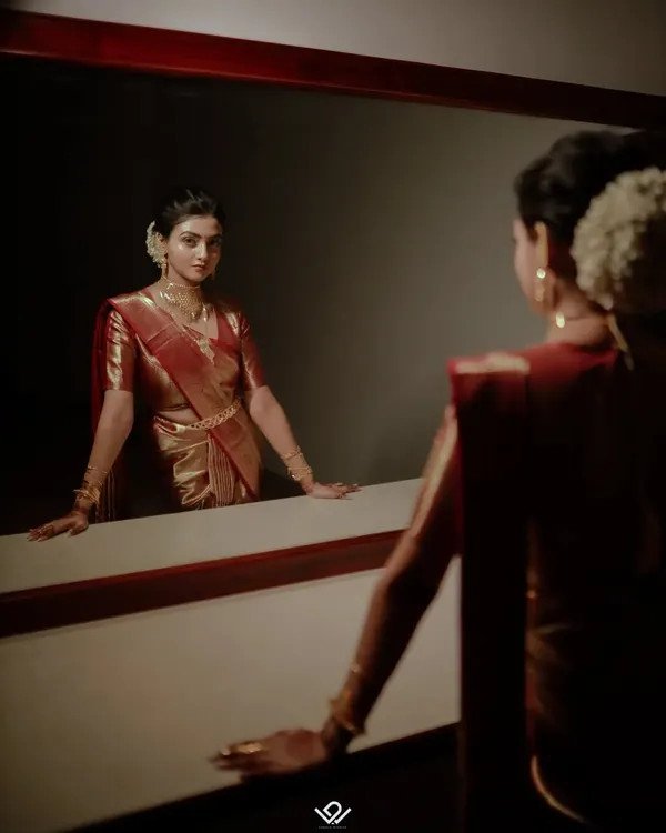 A dramatic and artistic bridal portrait, capturing the bride's reflection as she prepares for her big day.