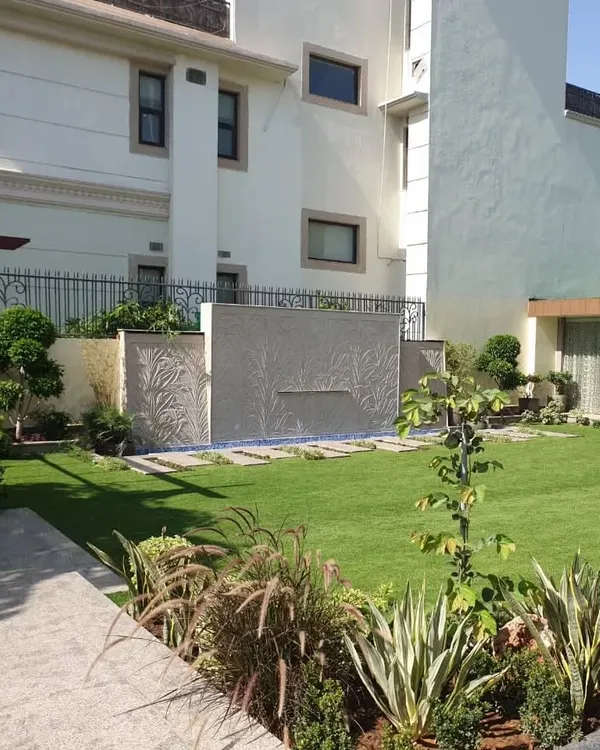A complete mini-farm landscape with a lush lawn, a modern water feature, and carefully selected border plants to create a private retreat.