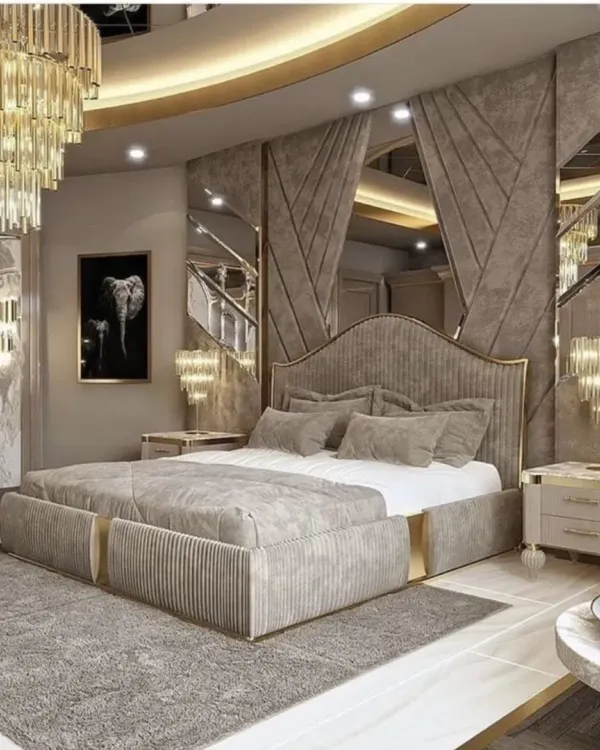 A truly grand bedroom design featuring a custom bed with a channeled headboard, gold accents, and extensive mirror work to create a sense of opulence and space.
