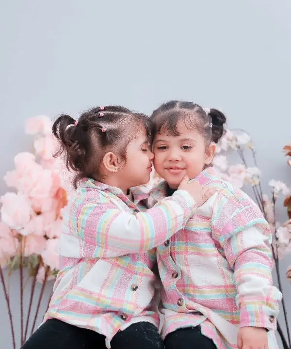 A sweet kiss between twin sisters during their boho-themed studio session. We love creating a playful space for kids to be themselves.