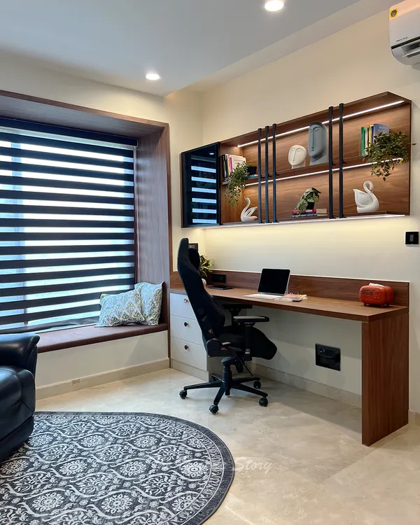 A modern contemporary study room designed for focus and comfort. The space features a custom floating desk with overhead shelves illuminated by LED lighting, an ergonomic chair, and a cozy bay window seat for breaks.