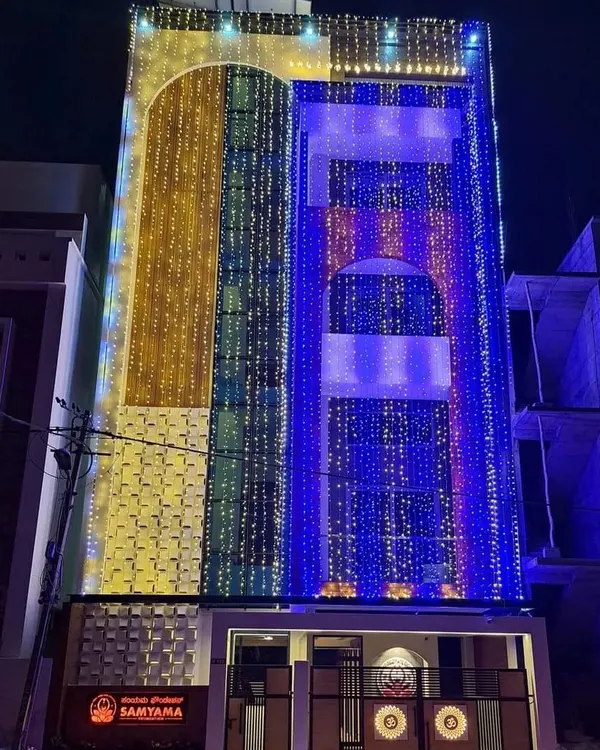 The Samyama Foundation Spiritual Centre illuminated at night for its inauguration. This striking image showcases the completed building, a multi-story beacon of light and spirituality in Bangalore.