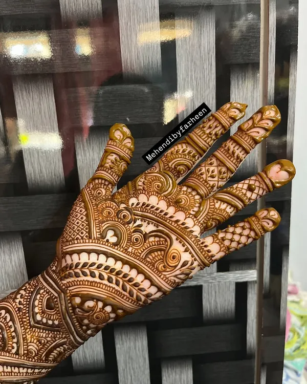 A beautiful Indo-Arabic design on the back of the hand. The bold lines create a lovely flow, complemented by fine, detailed fillers.